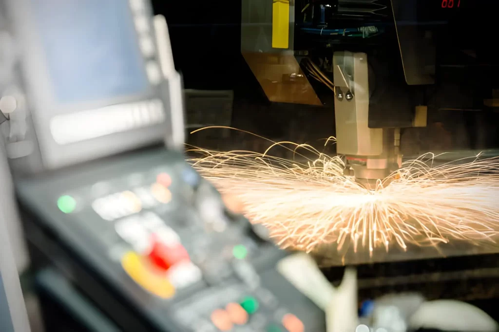 A high-speed laser cutting machine in operation, with its control panel visible.