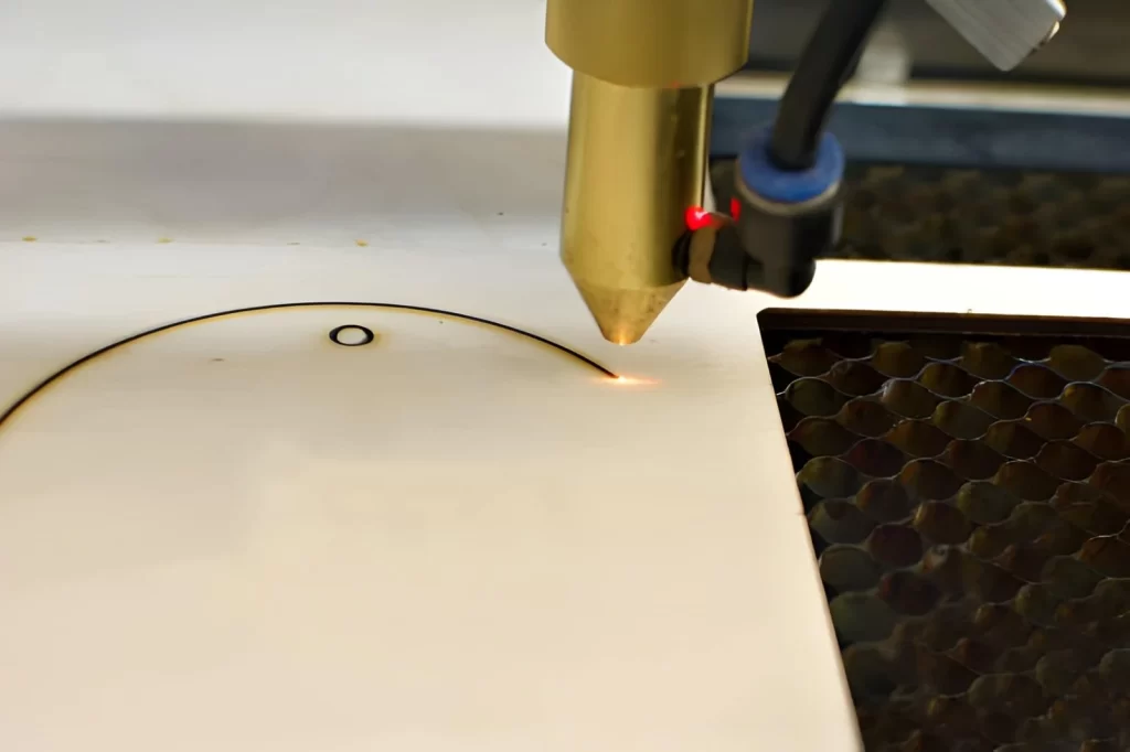 A close-up image of a laser engraver, laser burning on wood.