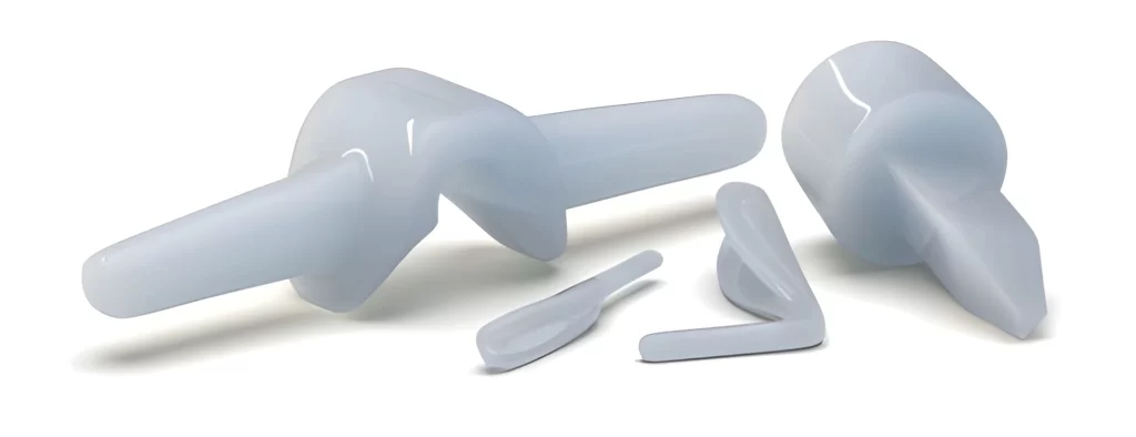 Molded silicone implants with smooth, uniform shape on a white background.