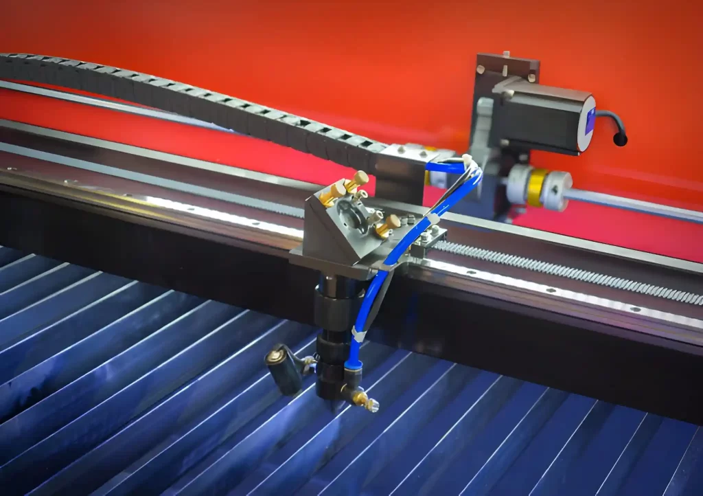 A laser cutter cutting a blue plastic sheet.