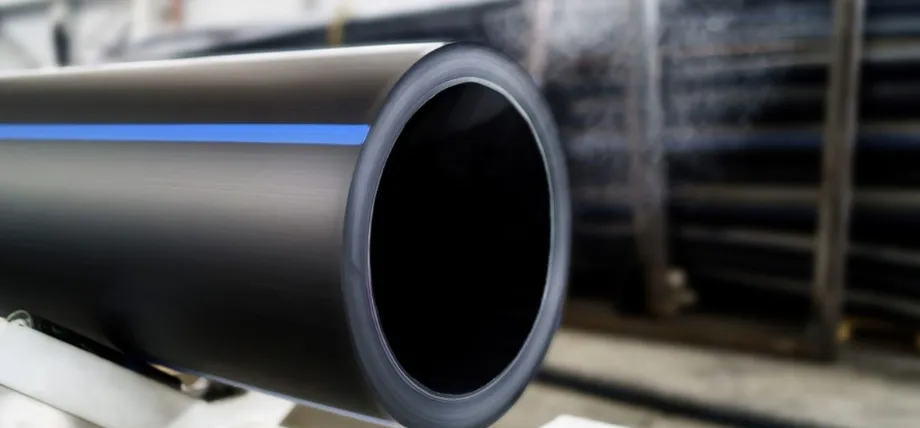 A close-up of a thick-walled black polyethylene pipe with a distinctive blue stripe, typically used for water or gas transport