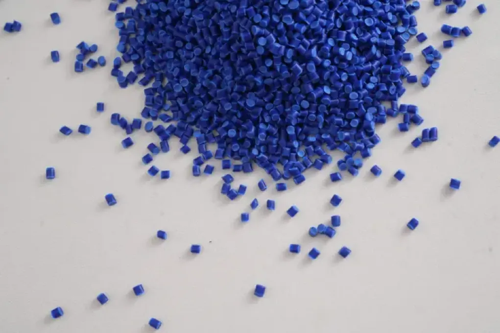 Blue TPE pellets scattered on a white surface