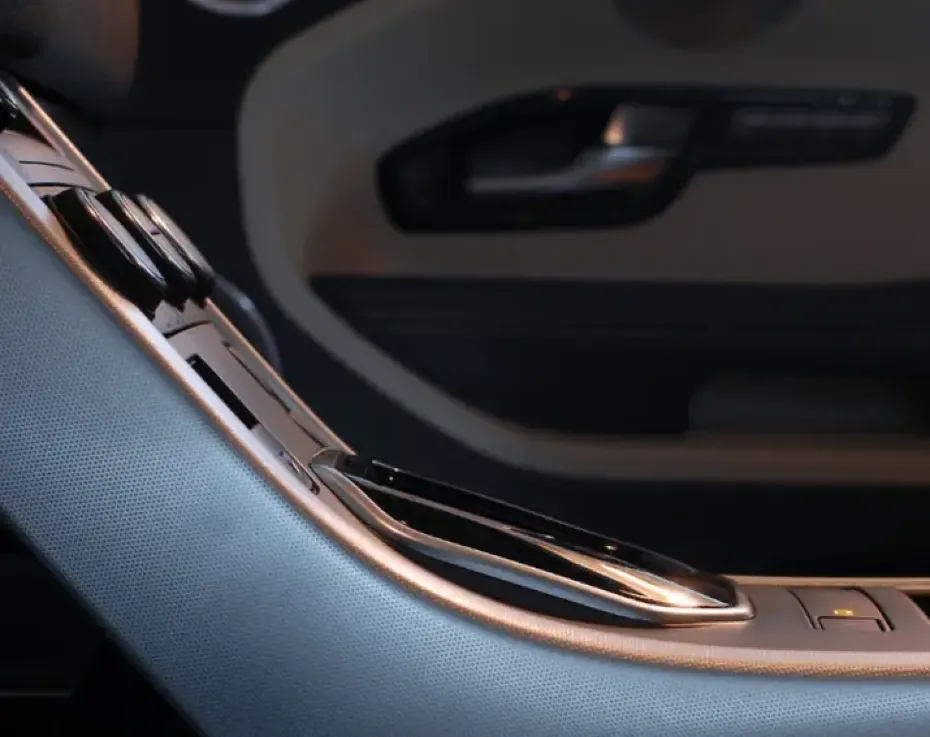 Close-up of TPE-molded car door panel trim with soft-touch surface, chrome accent strip, and window control buttons