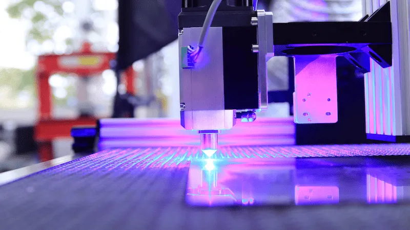 A glass sheet is being cut by a laser cutting machine.