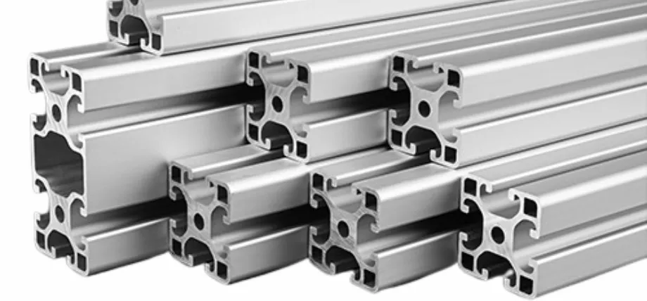 A stack of silver extruded wrought aluminum profiles with complex T-slot cross-sections and a smooth finish.