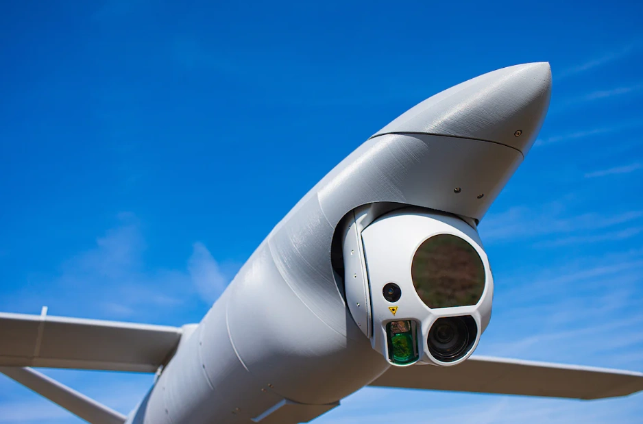 White drone nose with camera sensor gimbal against blue sky