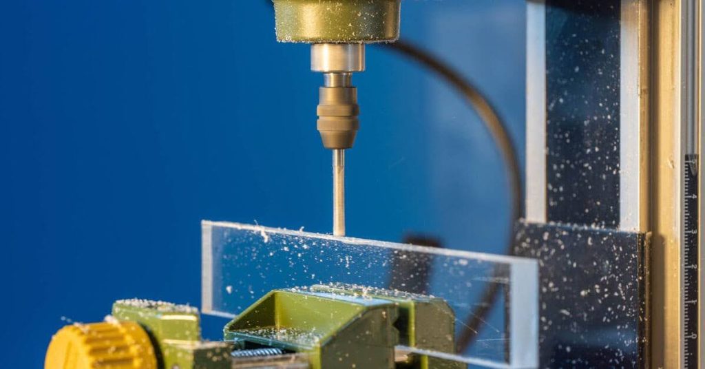 A close-up view of CNC cutting a clear acrylic workpiece