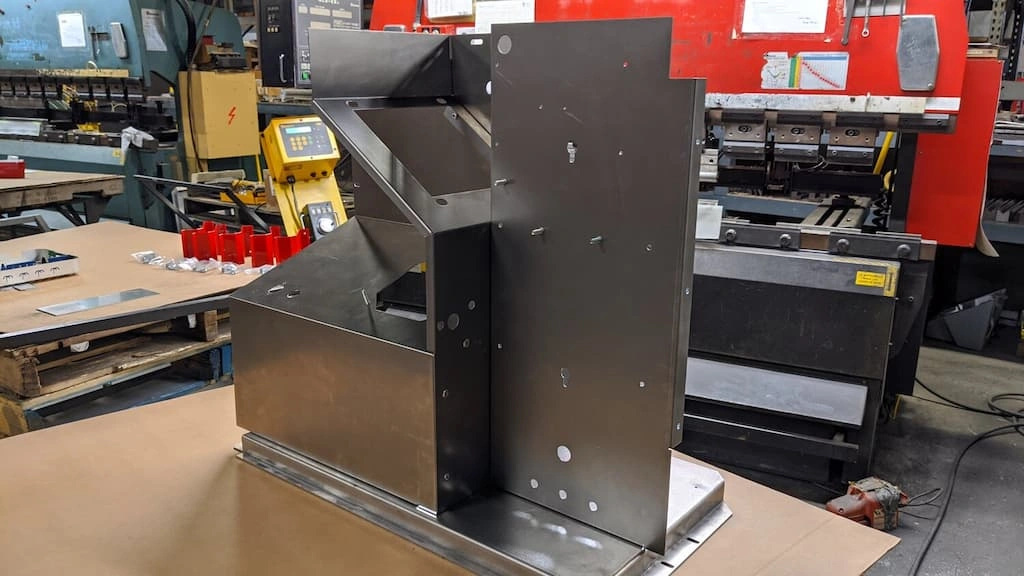 An image showing the assembly of a large metal sheet enclosure