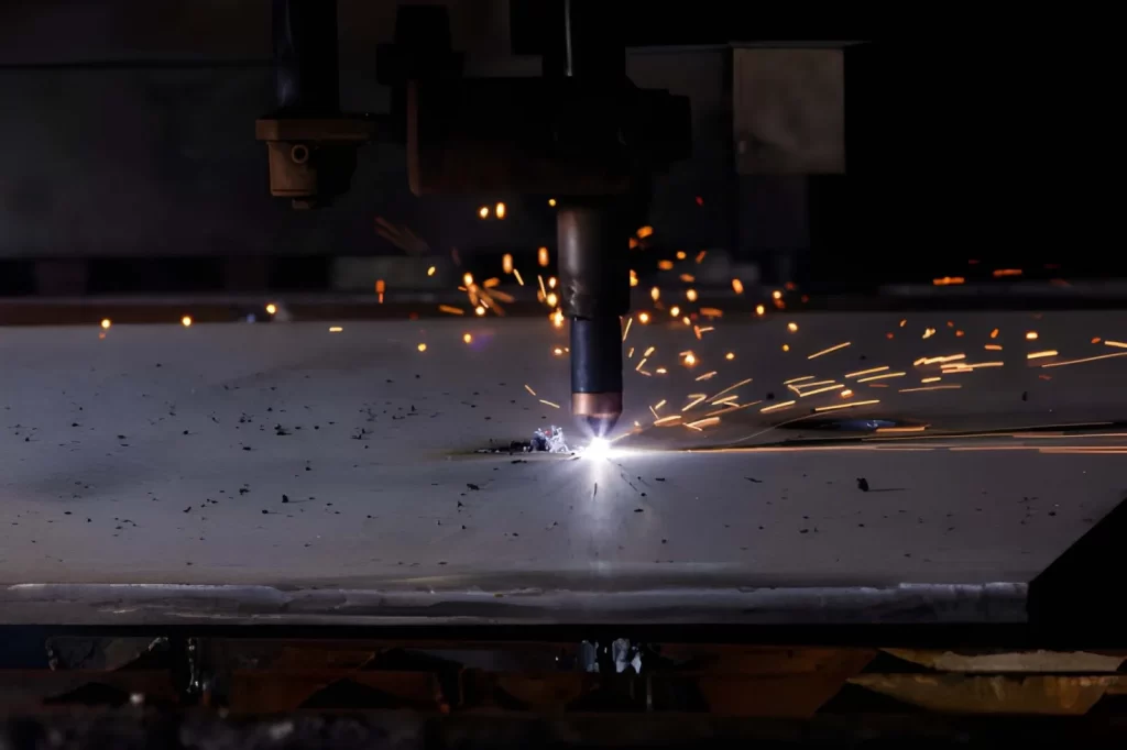 Close-up view of thick steel sheet during plasma cutting, showing the cutting arc and sparks.