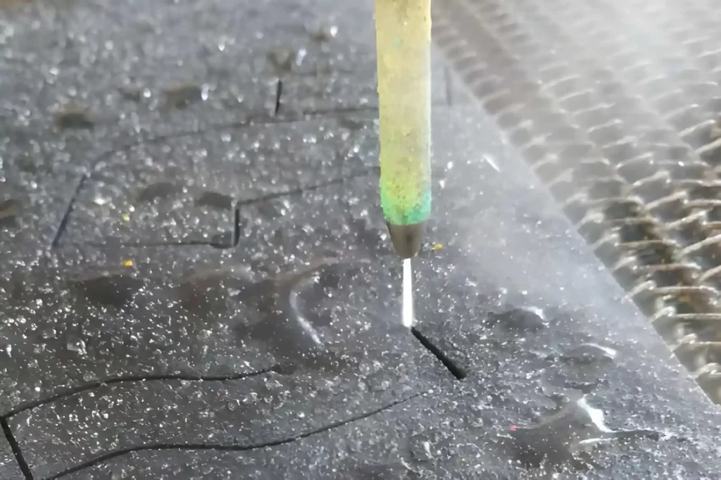 Simple view of the water cutting process, showing the cutting stream and workpiece.