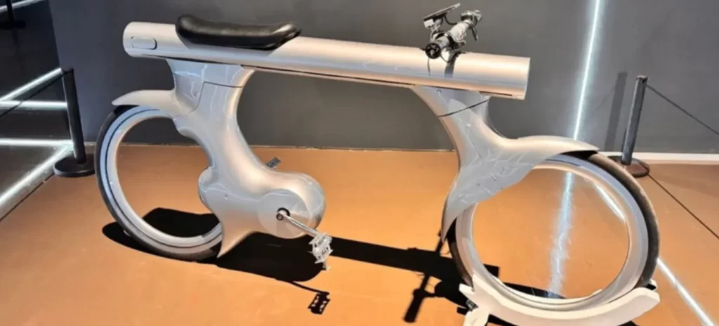 Futuristic aluminum bicycle prototype with sculpted hubless-look wheels and enclosed frame