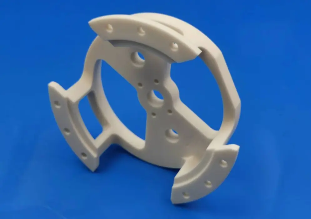 White ceramic prototype bracket with curved arms and multiple mounting holes