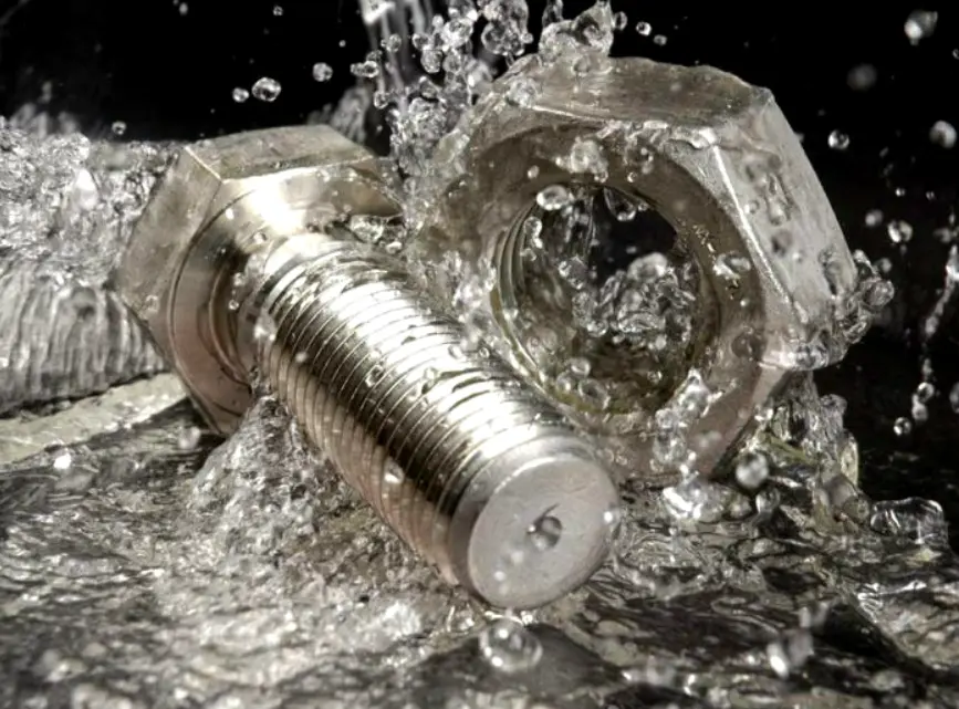 Metal bolt and nut splashed with water, illustrating environmental exposure and corrosion resistance