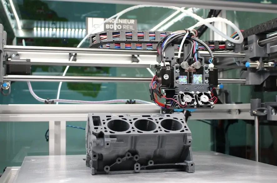 Large FDM 3D printer with dual extruder printing gray automotive engine block 