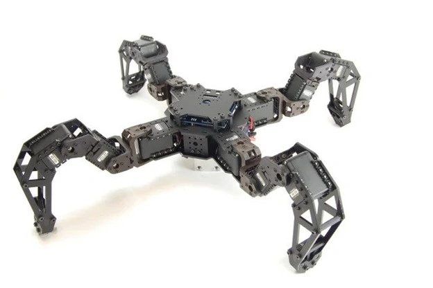 A Four-legged robotic prototype with articulated metal legs, multiple joints, motors, and electronic components