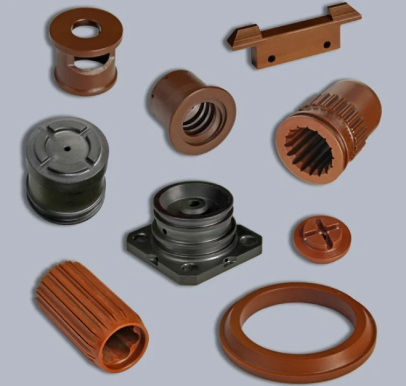 Machined Vespel polyimide components, including threaded bushings, splined sleeves, flanged fittings, and a sealing ring in amber and gray tones.
