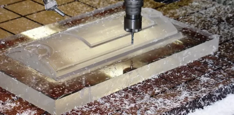 Een CNC-boormachine boort een transparante polycarbonaatplaat op de machinetafel.