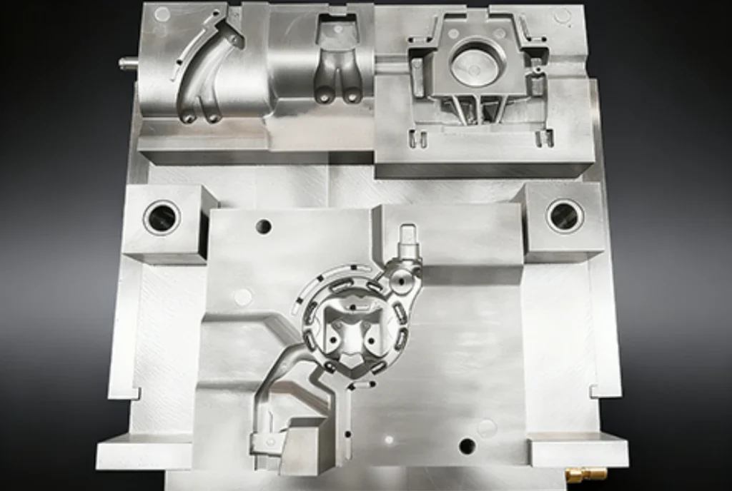 Multi-cavity family injection mold with three distinct part geometries including a curved component, a circular housing, and a complex lower cavity with integrated runner channels.