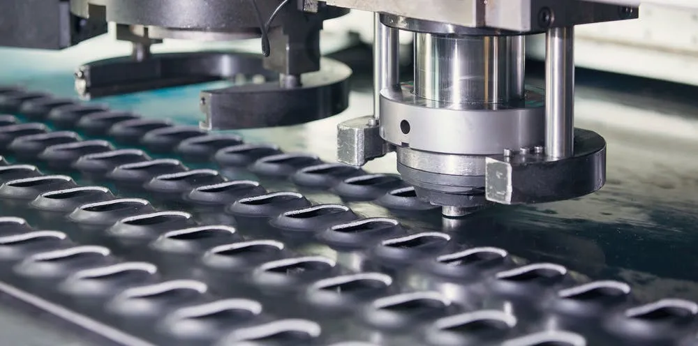 A CNC machine punching a sheet of metal for the formation of an enclosure