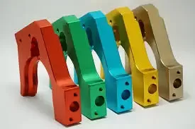 The Metallic Sheen of Anodized Precision Parts Five identical L-shaped aluminum brackets displayed in a row, showing different anodized colors.