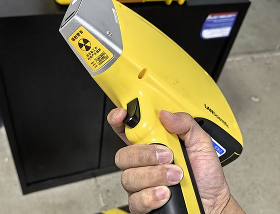 A handheld alloy analyser being pointed at a metal part to verify its grade