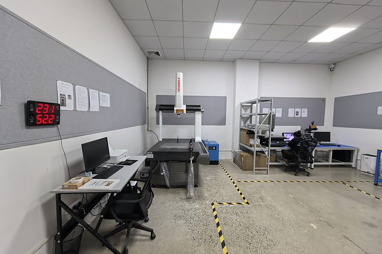 Metrology room with a coordinate measuring machine, measuring software on a monitor and a temperature and humidity display on the wall