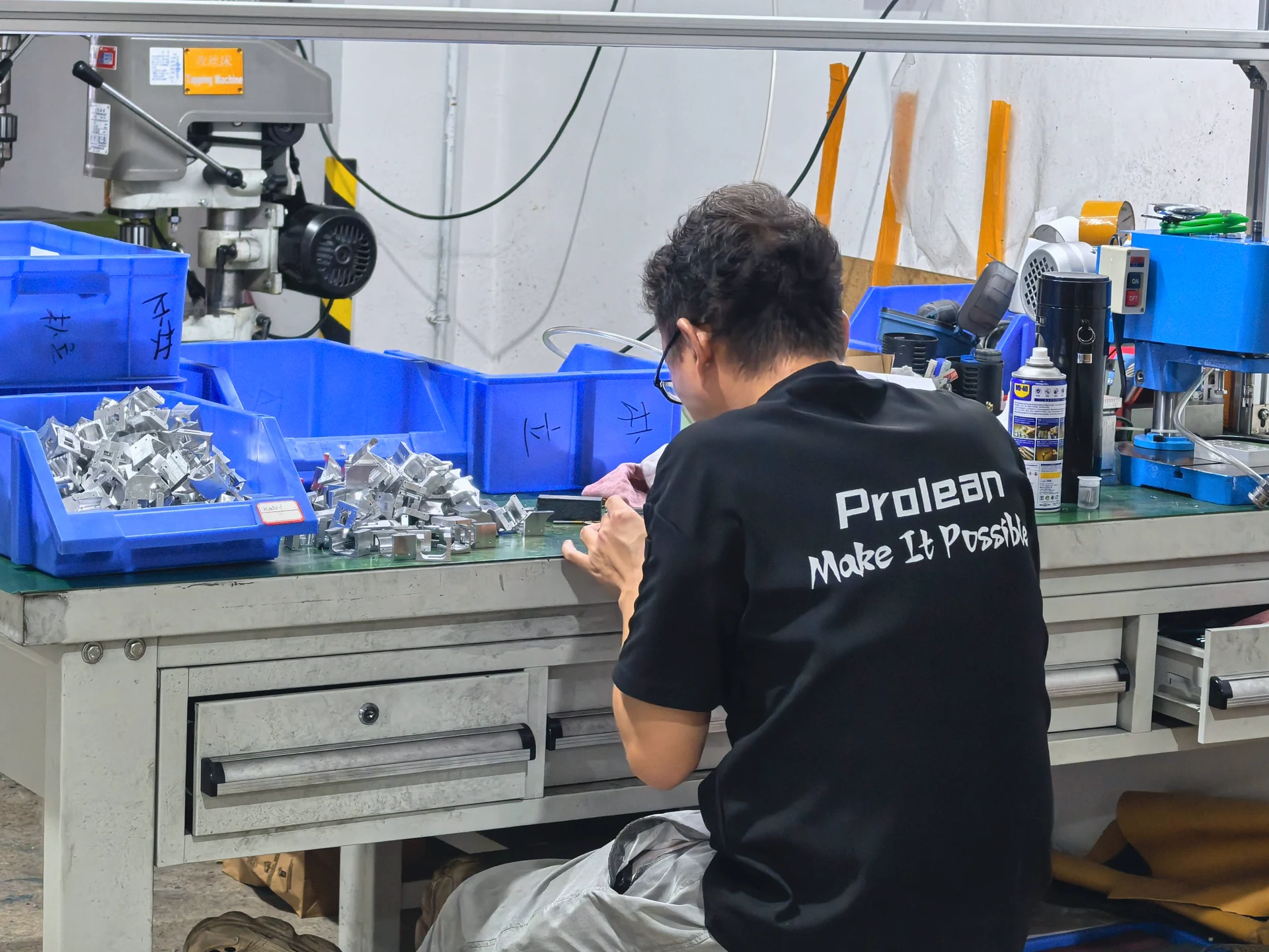 Prolean team member inspecting a machined part at the workbench