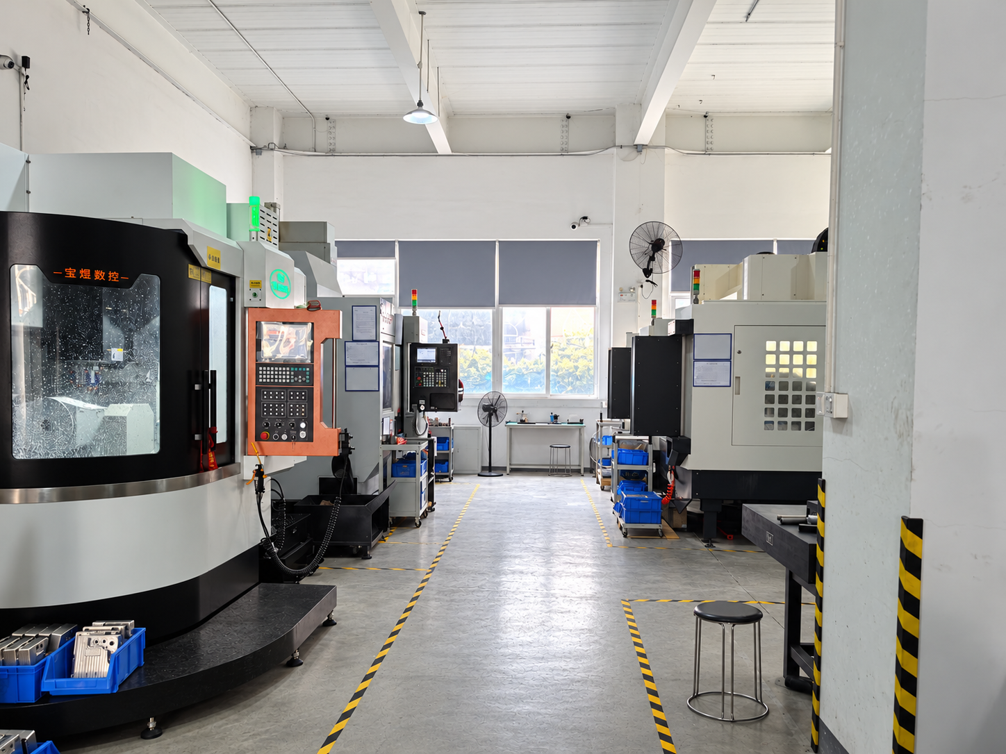 CNC workshop with machining centres along a marked aisle