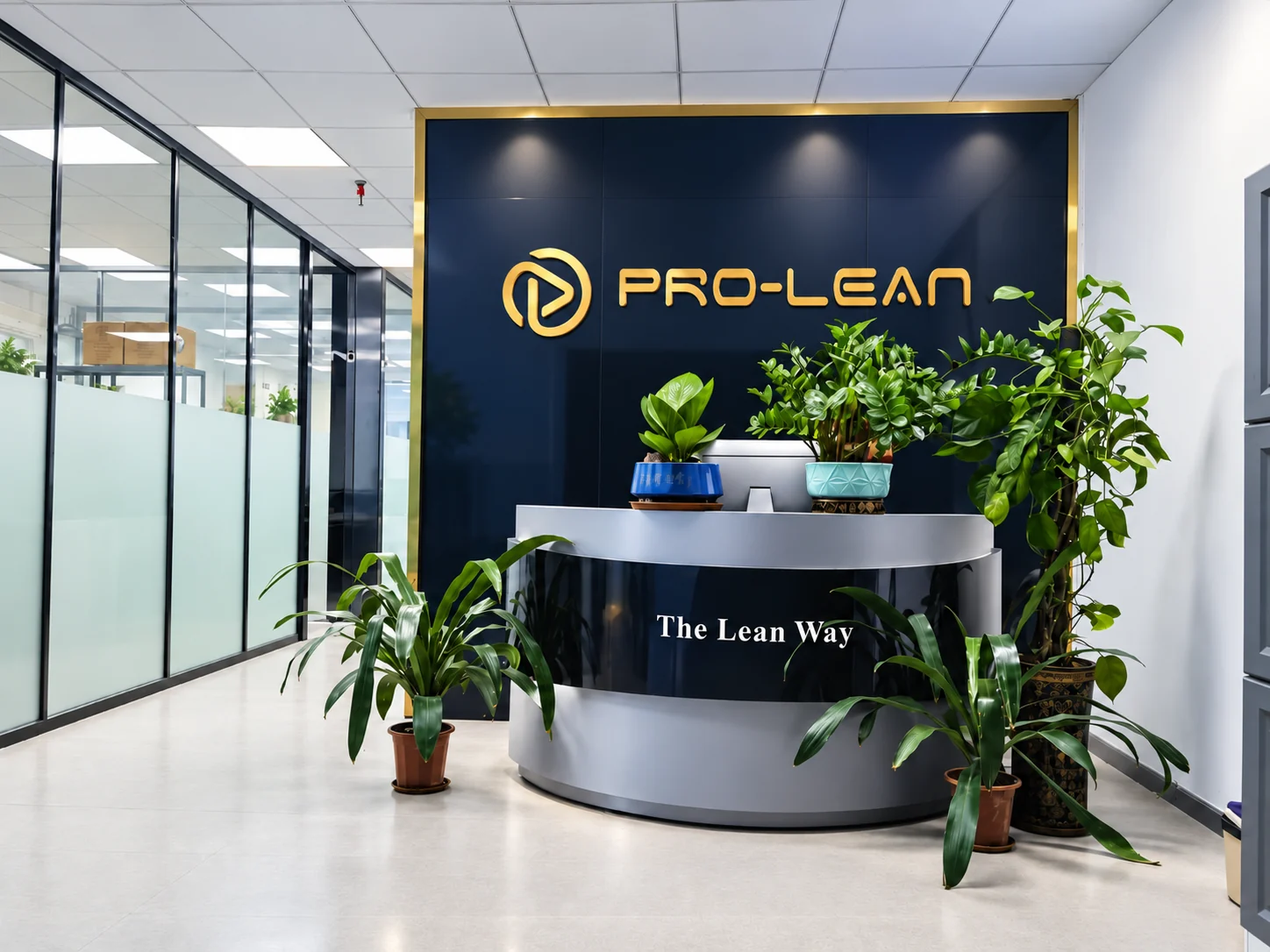 Prolean office reception with a branded wall, front desk and indoor plants