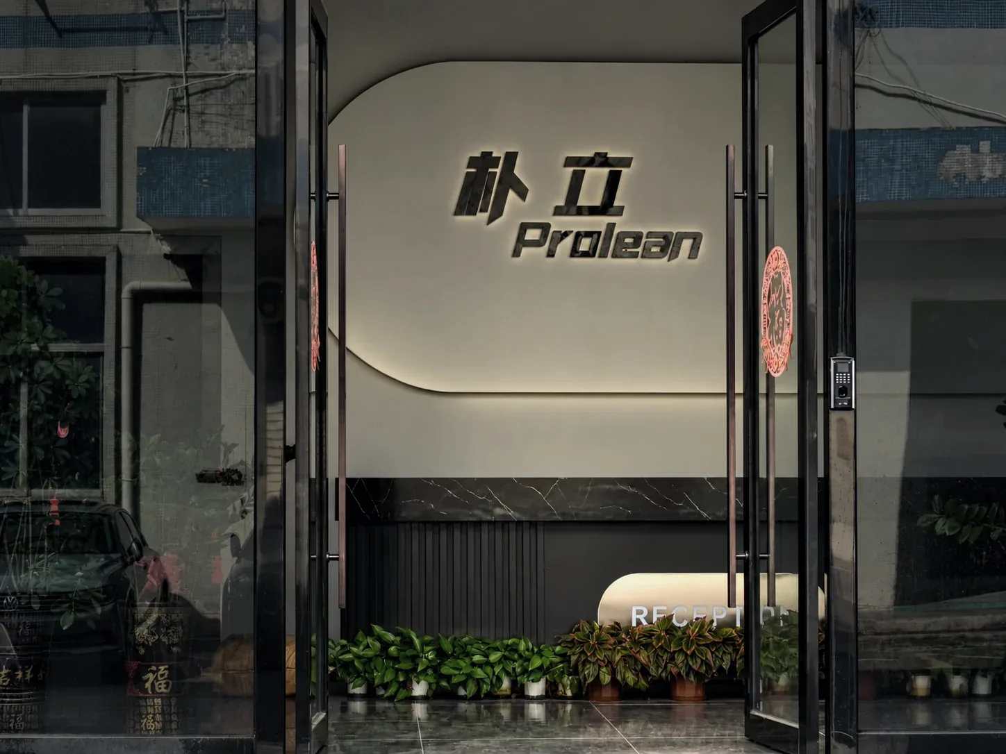 Prolean factory entrance with glass doors and an illuminated reception sign