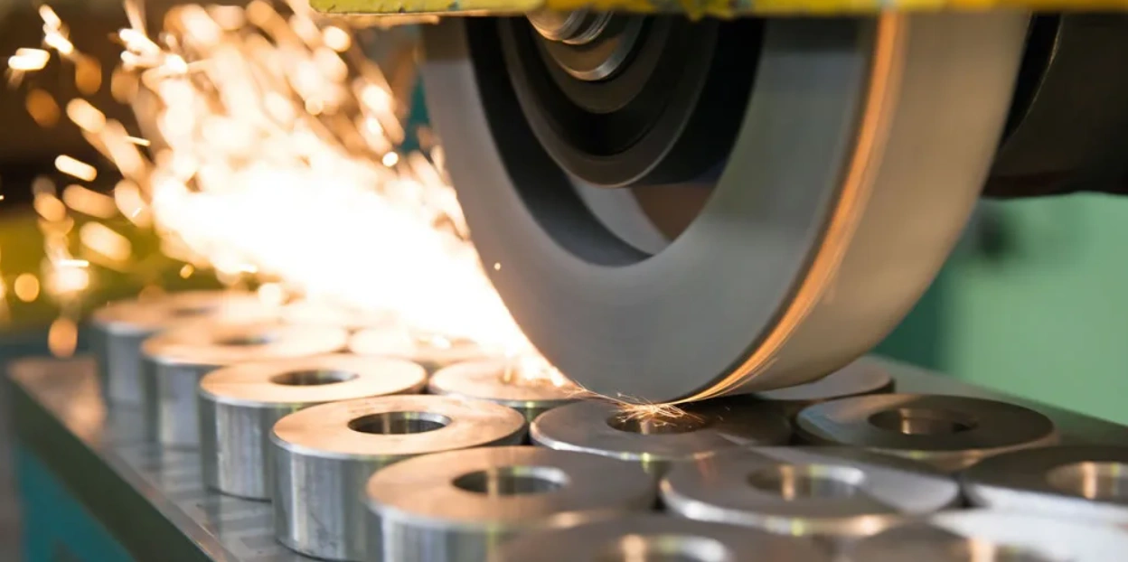 Abrasive wheel grinding flat faces of metal components