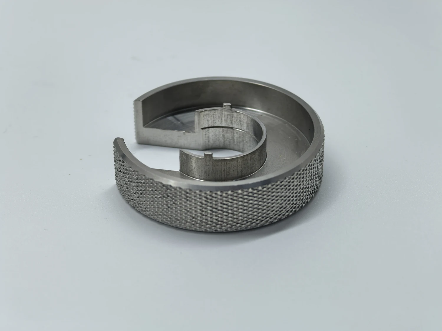 Metal ring with a diamond knurled outer circumference and machined internal features