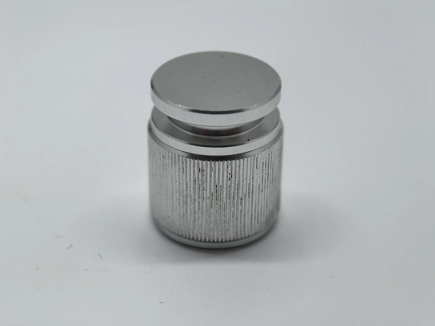 Cylindrical metal cap with a straight textured grip band