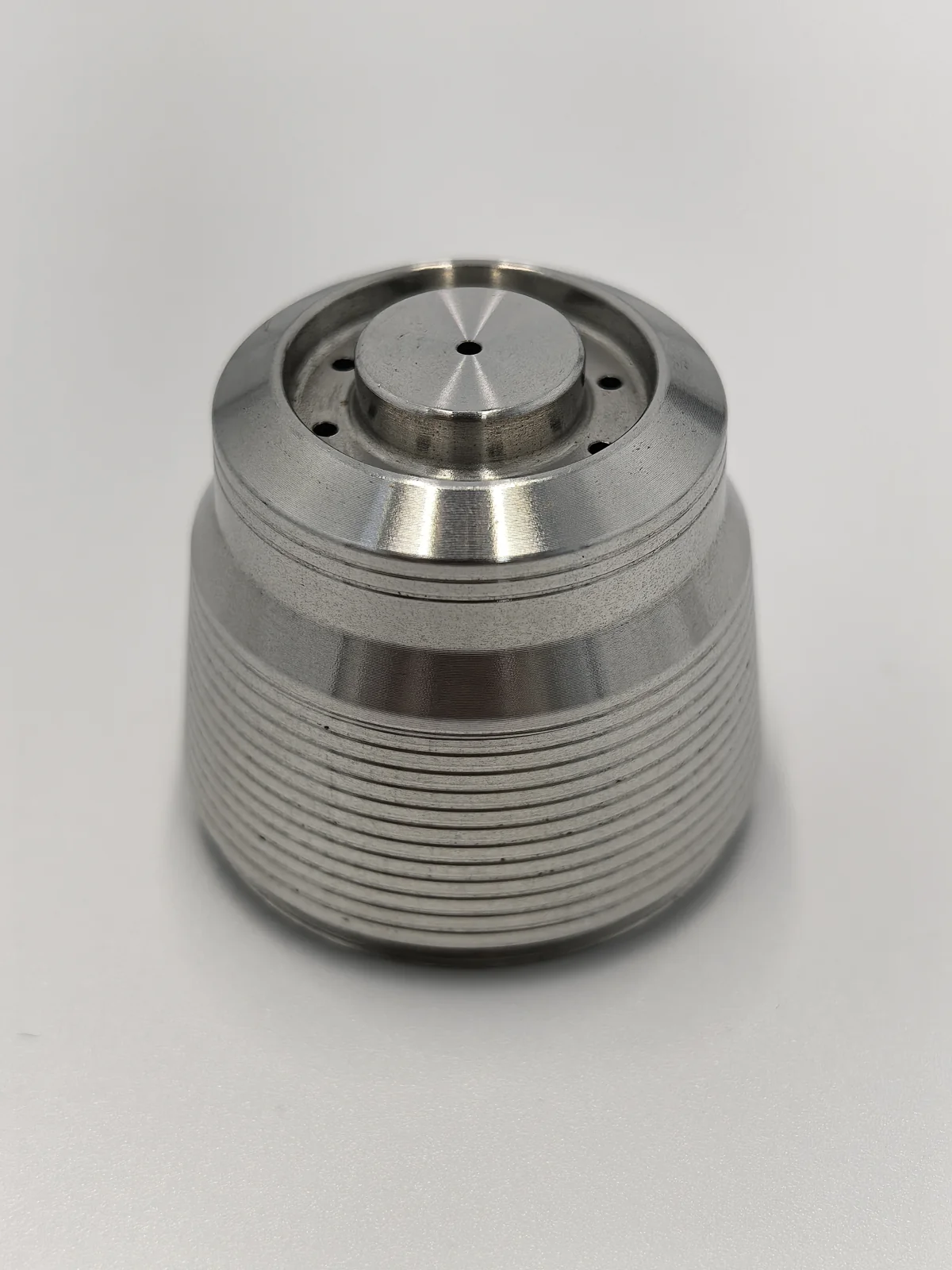 Finished cylindrical MIM component with circumferential grooves and small top holes