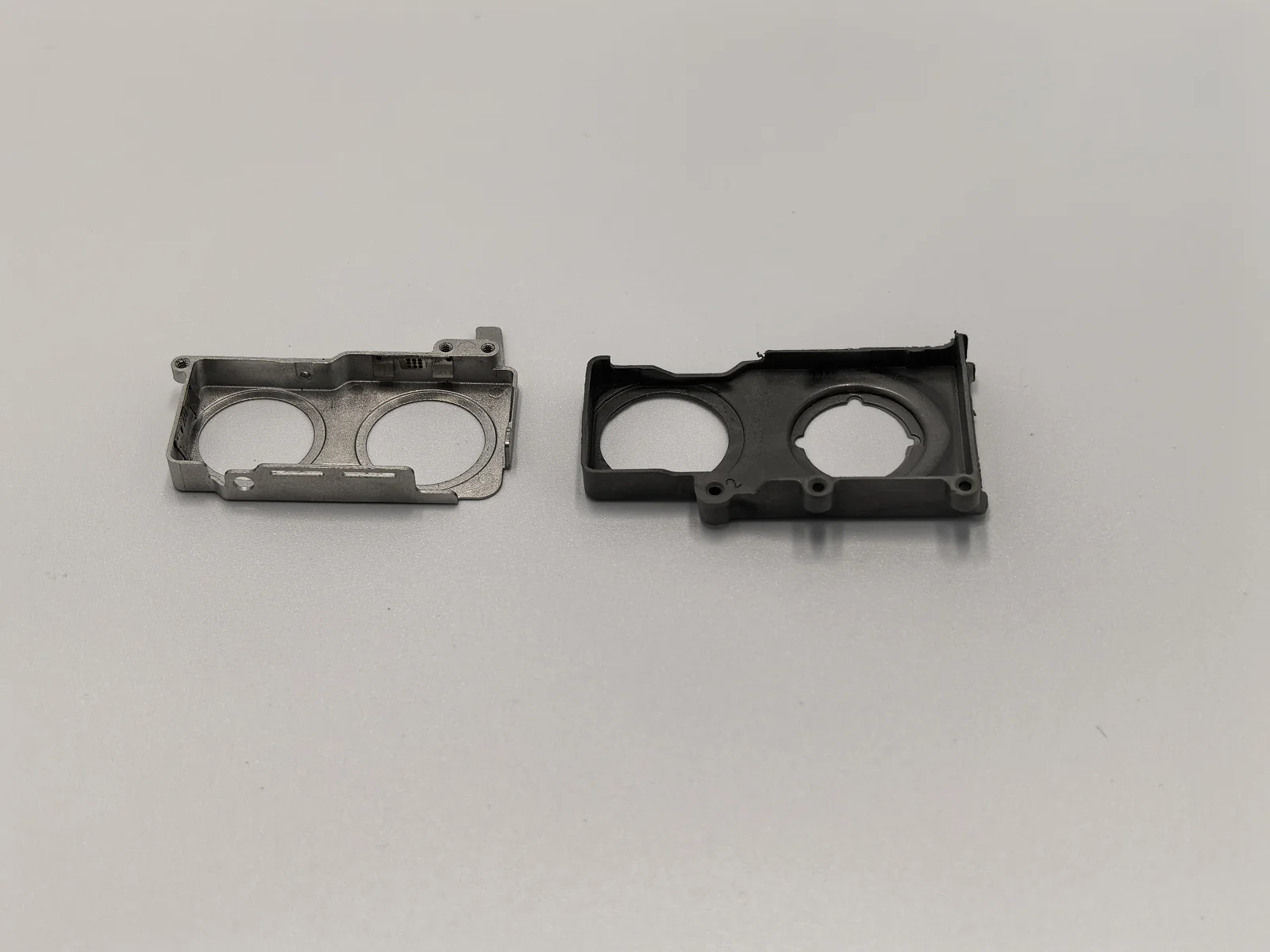 ProleanTech dual-aperture MIM frames: finished component at left and darker intermediate component at right