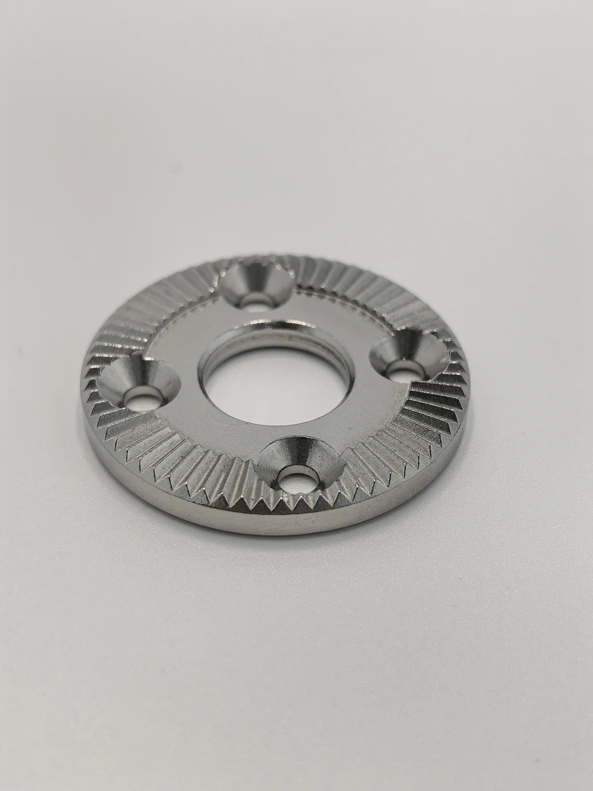 ProleanTech finished MIM component with radial teeth, central bore and four mounting holes