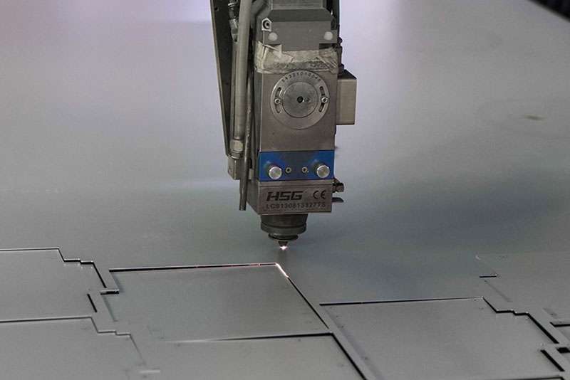 Laser cutting head processing a flat metal sheet