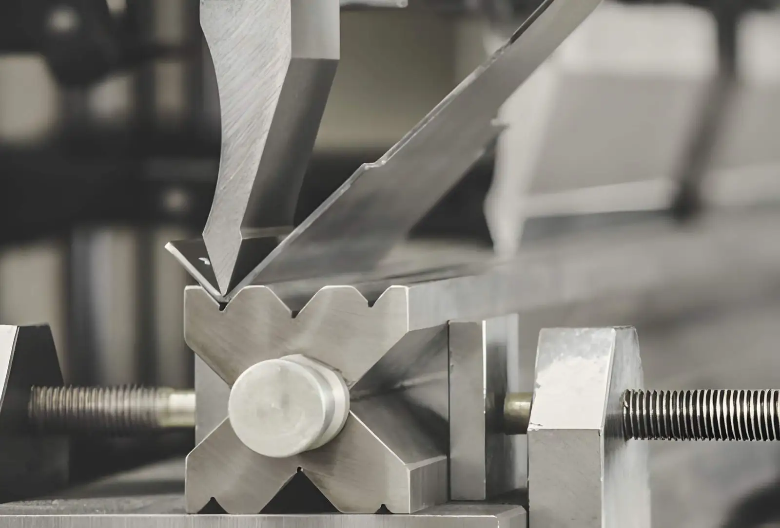 Close-up of sheet metal bending between a press brake punch and die