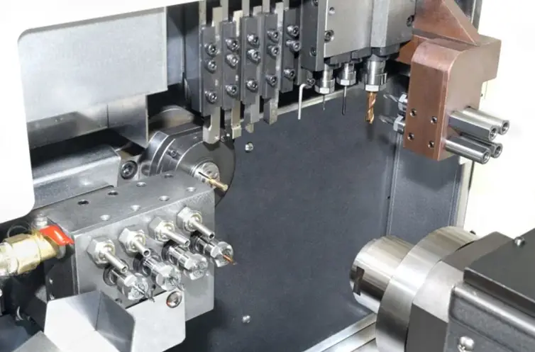 Swiss-type lathe interior with closely arranged cutting tools and spindle tooling