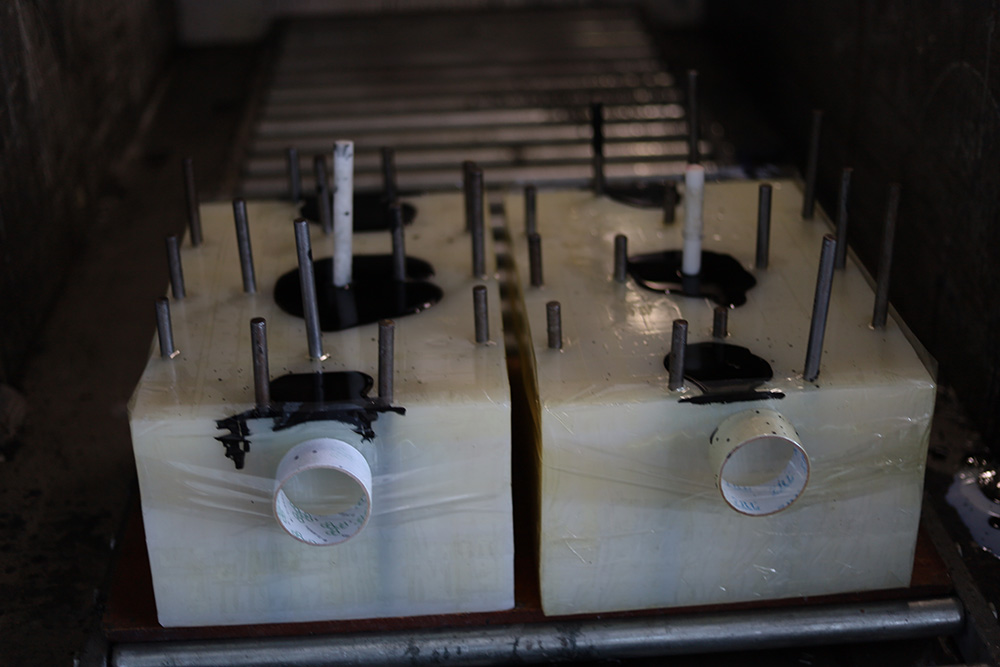 Two silicone molds with registration pins and fill openings in a workshop